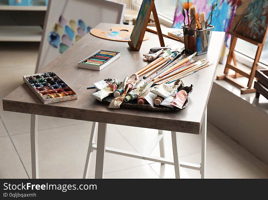 Table with tools and paints in artist s workshop