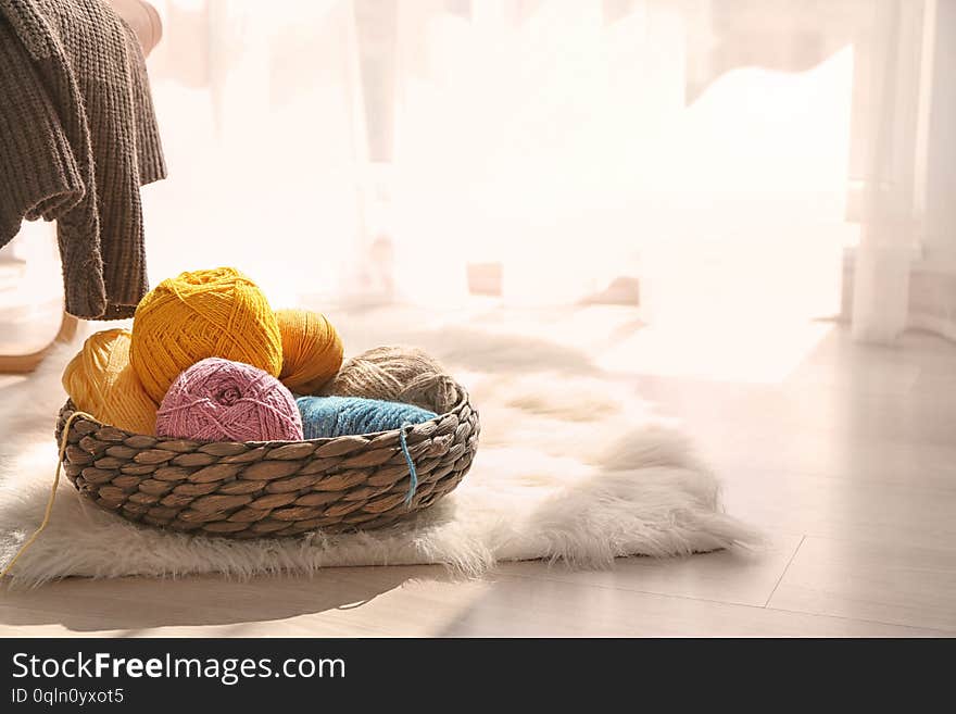 Wicker basket with knitting yarn on furry rug