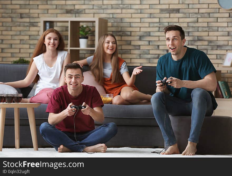 Young people playing video games at home