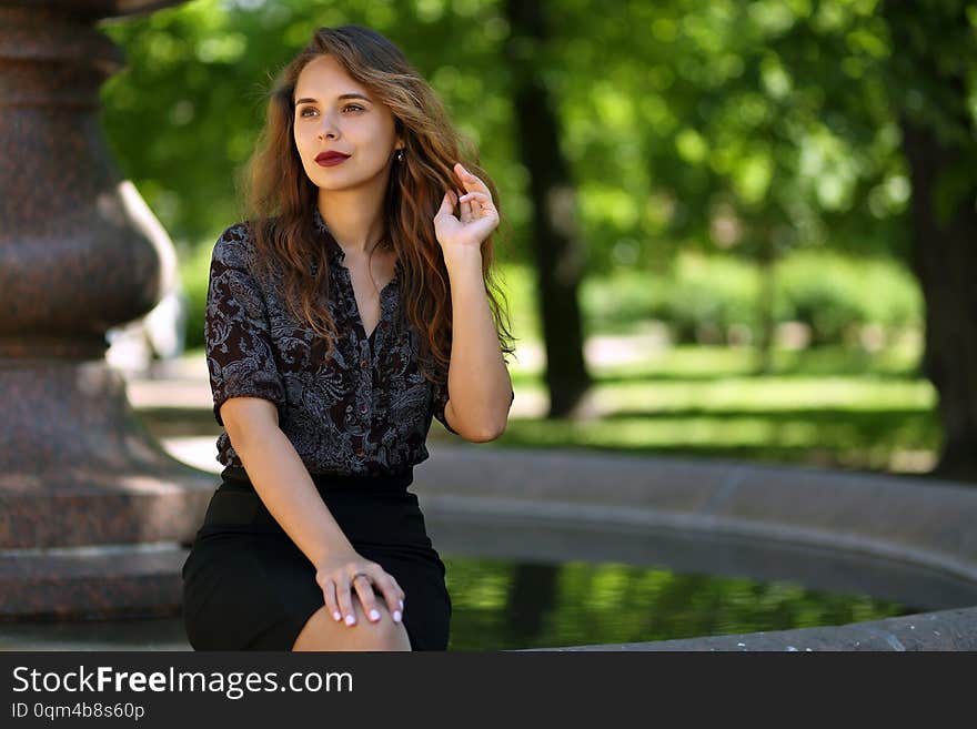 Beautiful, slender girl on a walk in the summer Park on the background of the fountain. Beautiful, slender girl on a walk in the summer Park on the background of the fountain