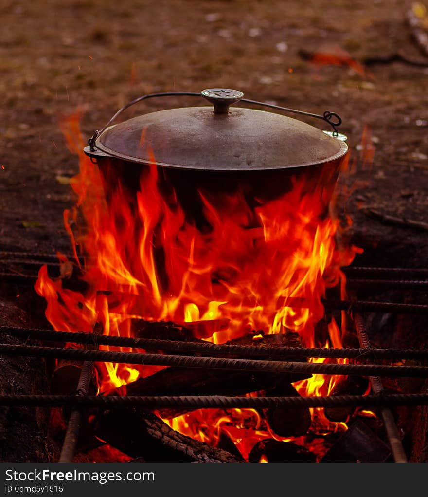 Food in the cauldron is prepared on the wood open fire in the summer in nature in the marching version. Food in the cauldron is prepared on the wood open fire in the summer in nature in the marching version