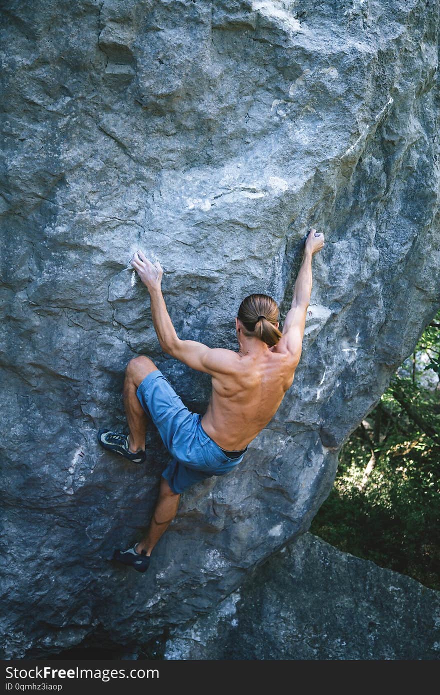 Athletic man climbing hard boulder problem in forest using special crash pads. Sport climbing, bouldering. Outdoor. Athletic man climbing hard boulder problem in forest using special crash pads. Sport climbing, bouldering. Outdoor.