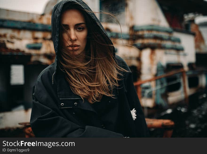 Young woman posing against the background of an old abandoned ship