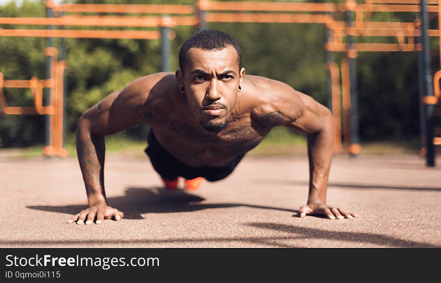 Muscular Man Doing Push Ups On Sports Ground