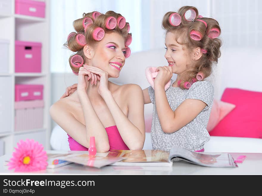 Portrait of happy  Mother and little daughter with hair curlers at home