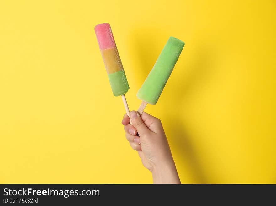 Woman holding delicious ice creams against color background