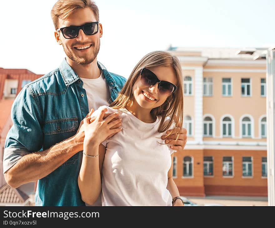 Portrait of smiling beautiful girl and her handsome boyfriend. Woman in casual summer jeans clothes. Happy cheerful family. Female having fun on the street background