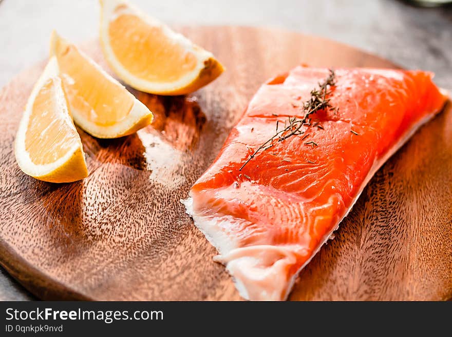 Raw salmon fish filet with lemon and spices. On a wooden background