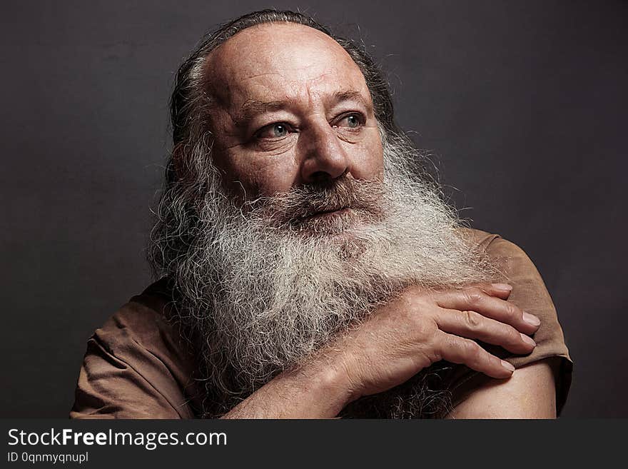 Old man sixty, seventy, with a long beard with big smile on a dark background