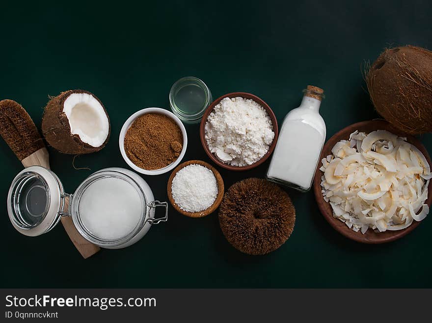 Variety of products made from coconut on dark green background with copy space. Variety of products made from coconut on dark green background with copy space