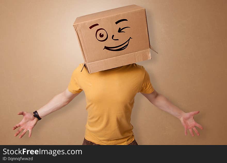 Handsome man standing and gesturing with a carton box on his headn. Handsome man standing and gesturing with a carton box on his headn