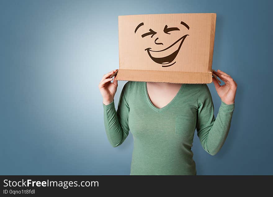 Young girl standing and gesturing with a cardboard box on her headn. Young girl standing and gesturing with a cardboard box on her headn