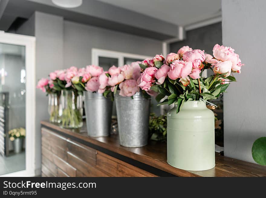 The counter of the flower shop. Pink peonies in a metal vase. Beautiful peony flower for catalog or online store. Floral