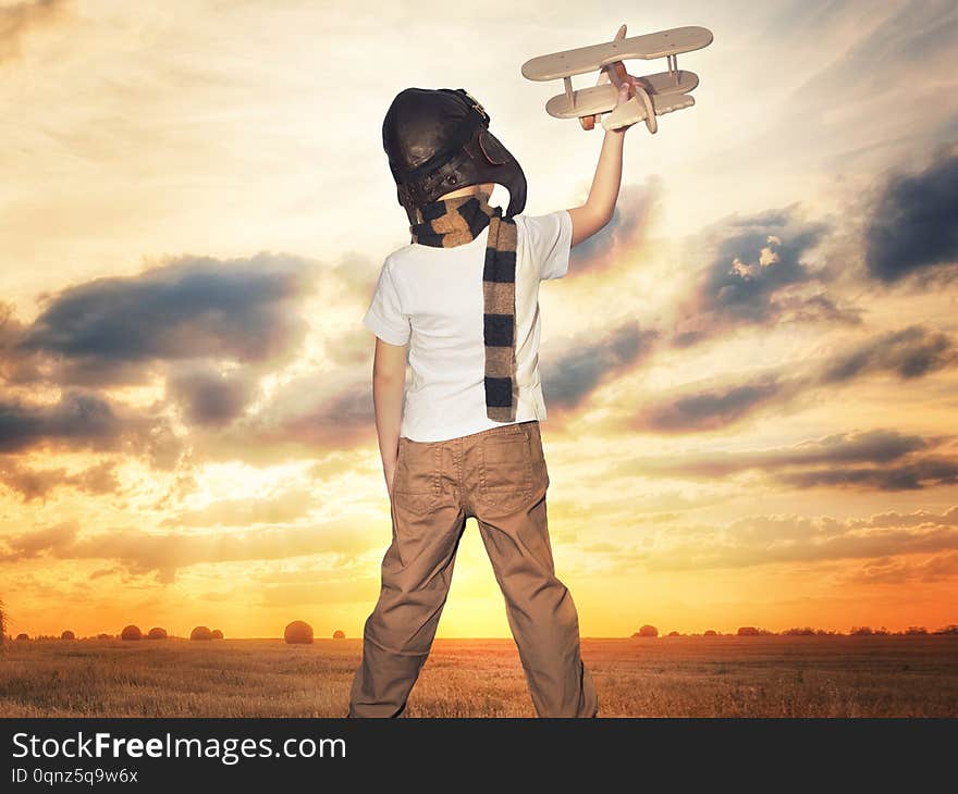 Child pilot aviator with airplane dreams of traveling in summer in nature at sunset	.Child pilot aviator