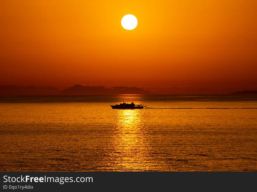 Silhouette of a ship passing in the reflection of the Sun in the Ionian Sea, Sarande, Albania.