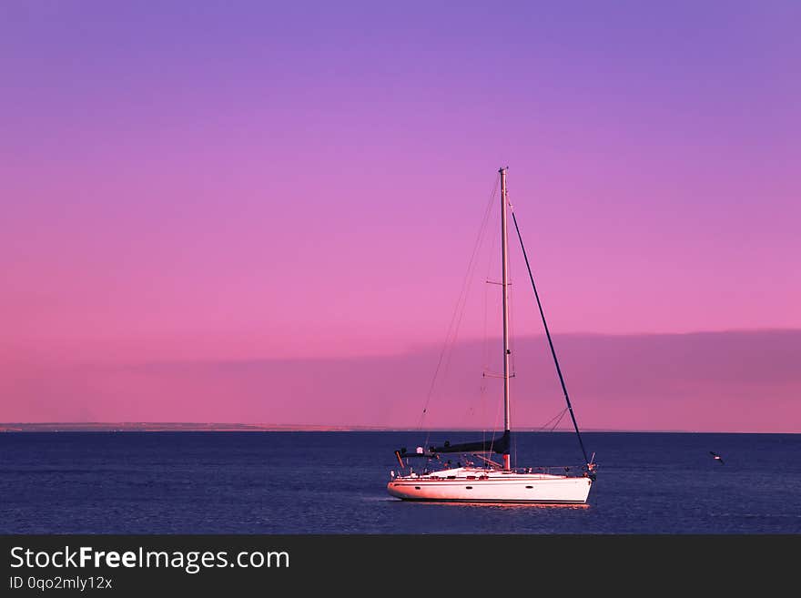 Red sunset over the blue sea, purple sky and yachts in the parking lot. Summer sea scenic  landscape in the beautiful evening