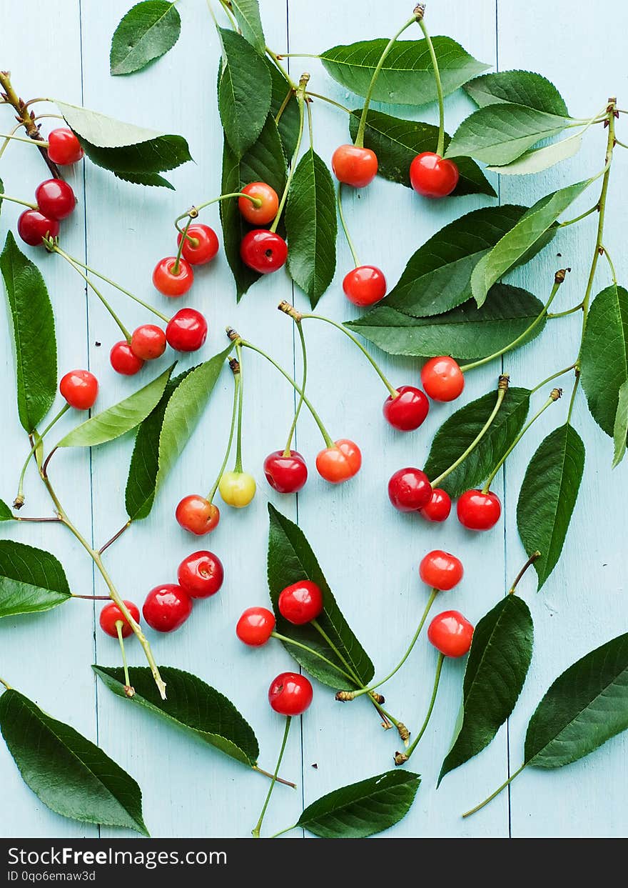 Cherries with leaves on wooden background. Shallow dof. Cherries with leaves on wooden background. Shallow dof