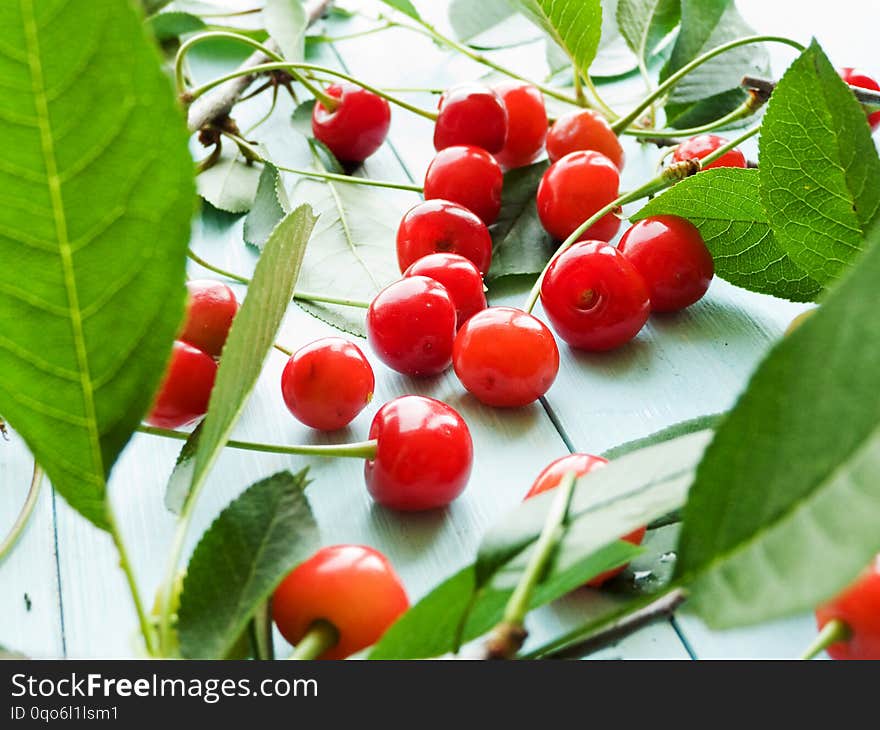 Cherries with leaves on wooden background. Shallow dof. Cherries with leaves on wooden background. Shallow dof