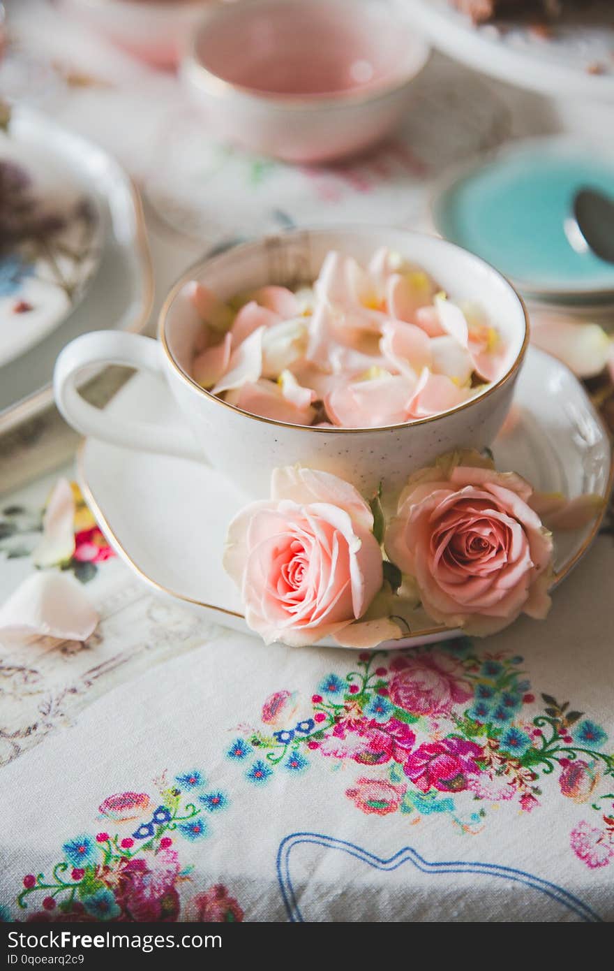 A close up of a cup with tea decorated with roses