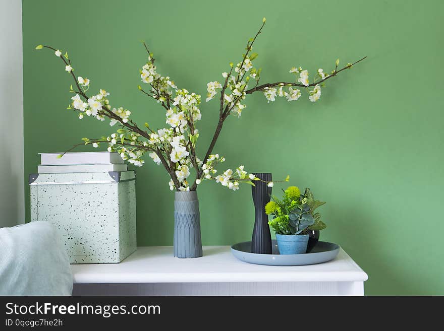 Beautiful flower in a vase on green wall in living corner at home