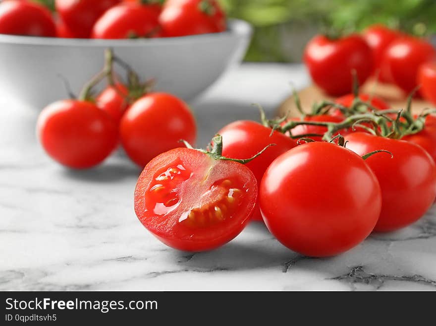 Branch of fresh cherry tomatoes on marble background