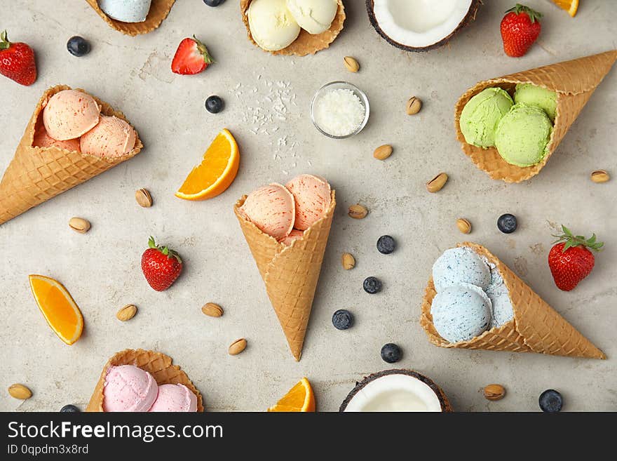Flat lay composition with delicious ice creams in waffle cones on table