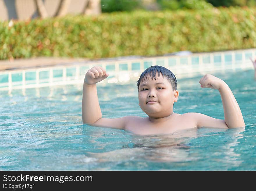 Obese fat boy show muscle in swimming pool, exercise and healthy concept