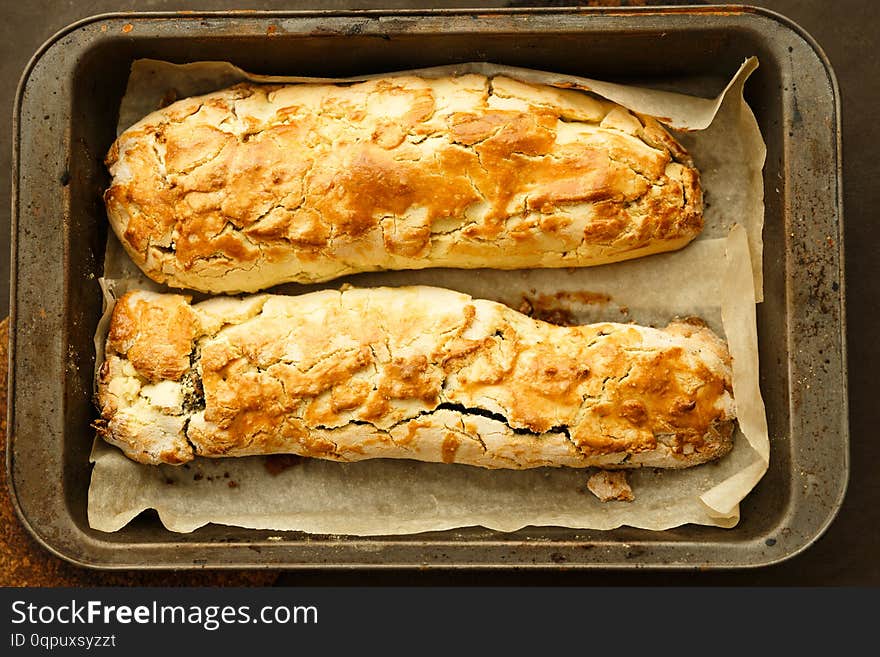 Two Rolls With Raisin And Nuts On The Pan And Baking Paper