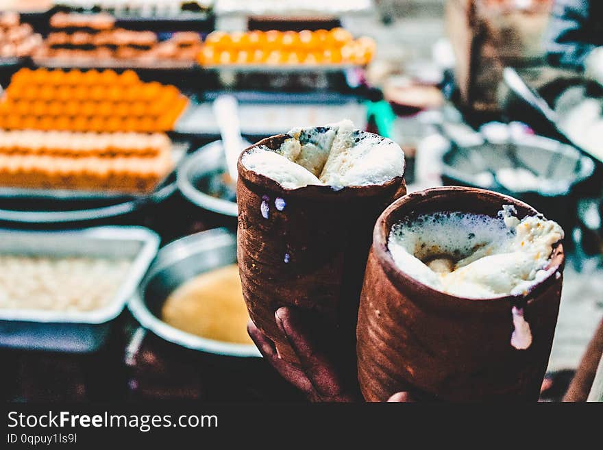 Two ceramic filled with Lasse, a traditional Indian yogurt drink in a food market