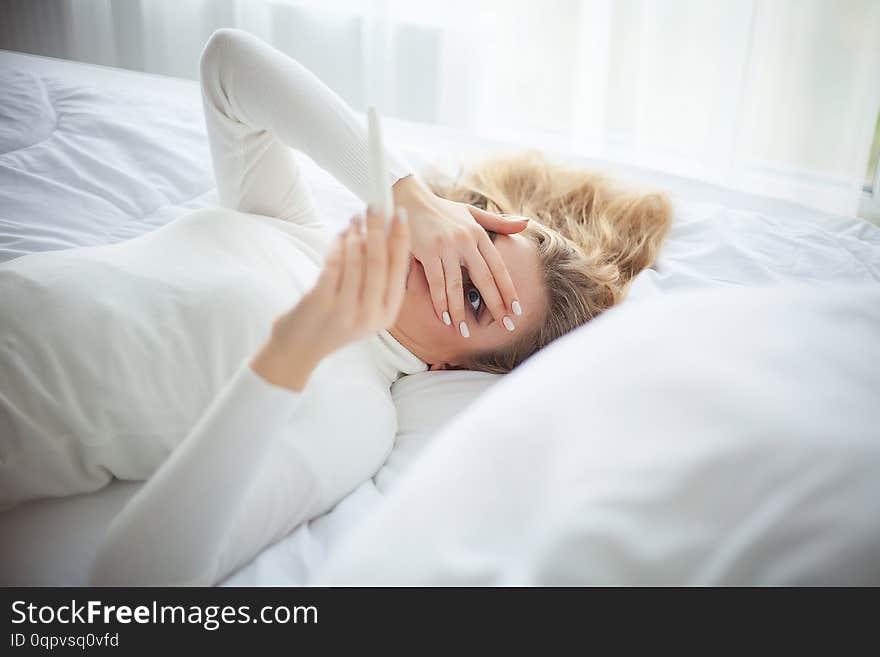 Positive pregnancy test. Young woman feeling depressed and sad after looking at pregnancy test result at home