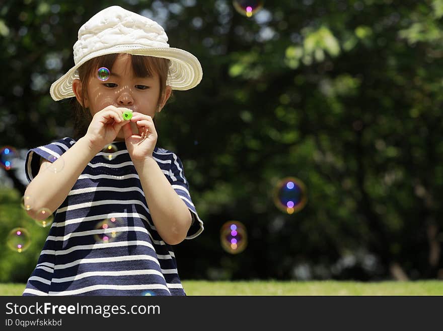 Japanese girl playing with bubble under the blue sky 4 years old