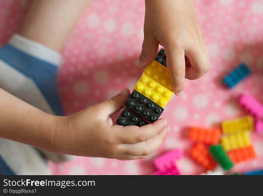 Small hands of the child collects the bright plastic colored Designer. Educational toys and Early learning