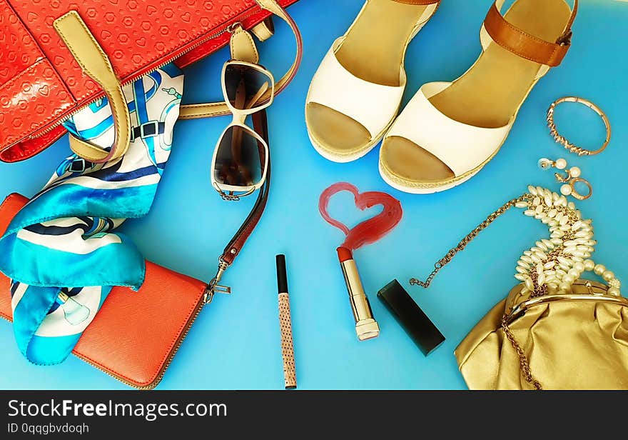 White summer sandals White pearl,red purse,red bag, Women  accessories ring watches 
hat  bow   cosmetic purse jewelry  fashion  pink gold on blue background sunglass red  lipstick copy space. White summer sandals White pearl,red purse,red bag, Women  accessories ring watches 
hat  bow   cosmetic purse jewelry  fashion  pink gold on blue background sunglass red  lipstick copy space