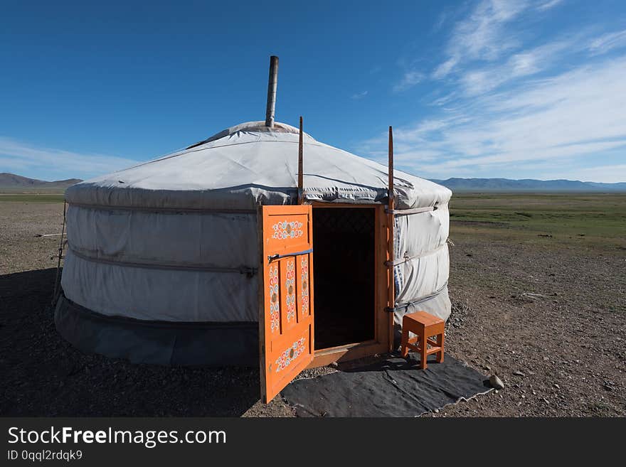 A ger with orange painted door at its summer location under sunny skies in central Mongolia, Asia. A ger with orange painted door at its summer location under sunny skies in central Mongolia, Asia