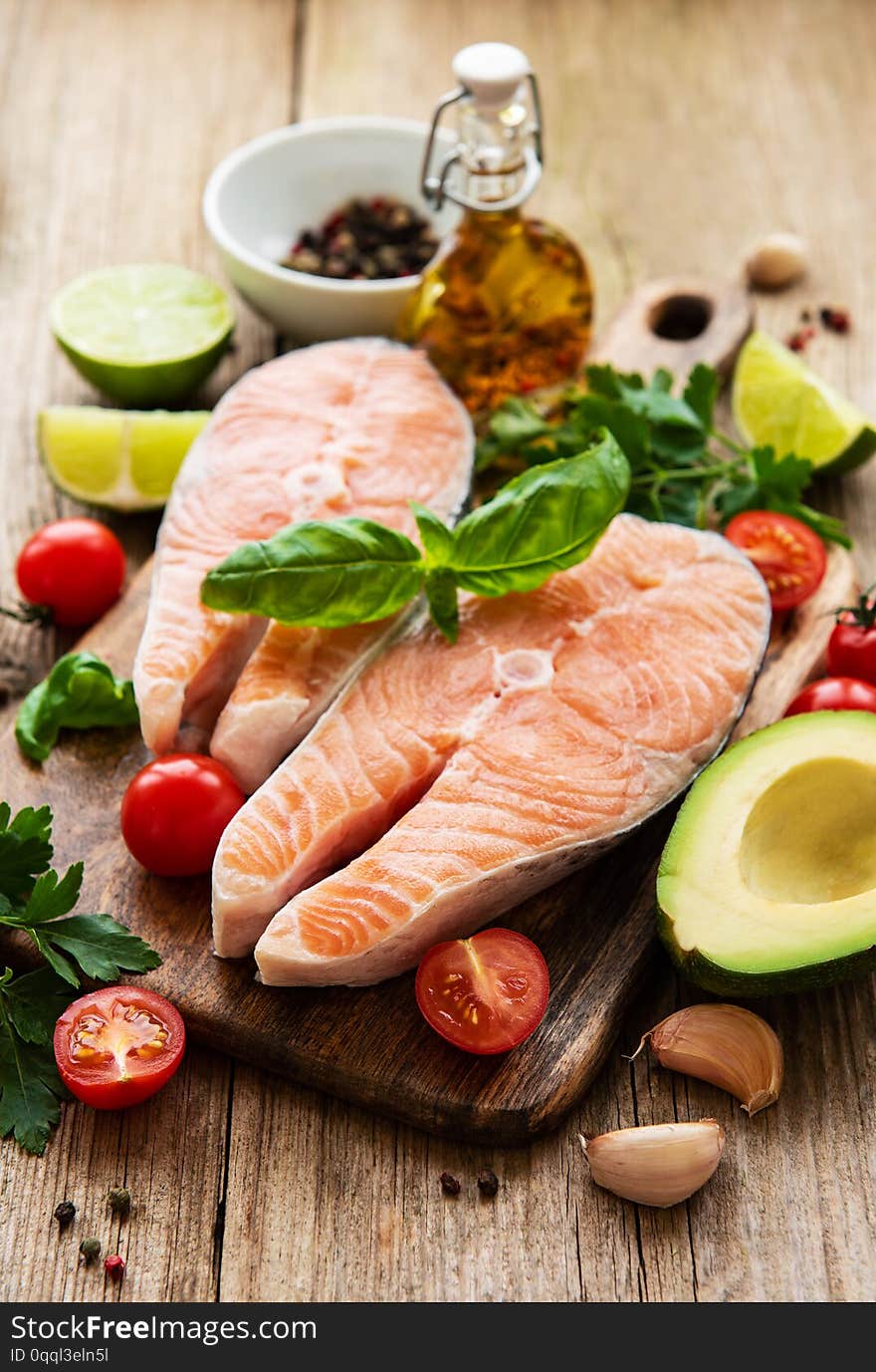 Raw salmon steaks and ingredients on a old wooden table