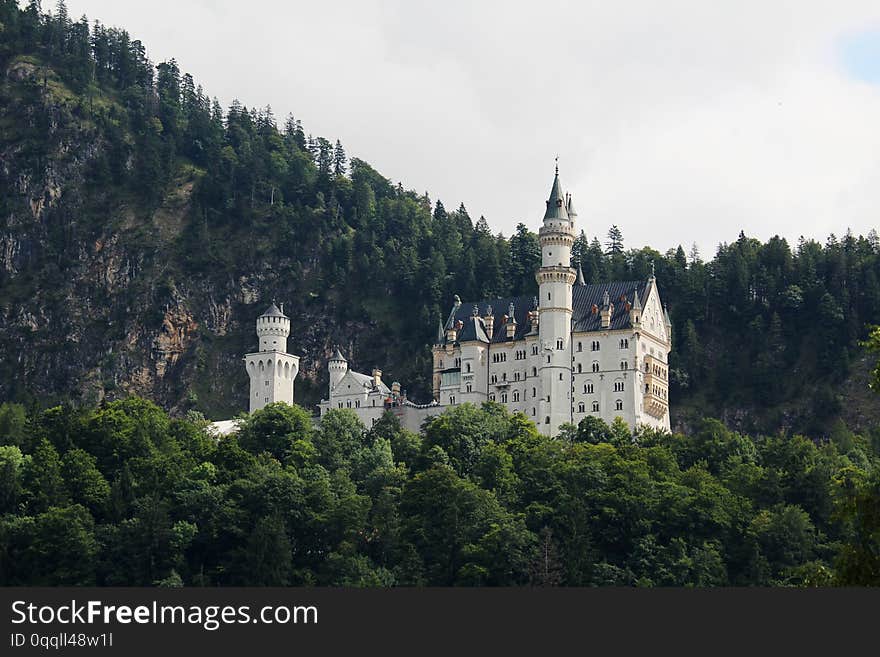 Neuschwanstein Castle is a 19th-century Romanesque Revival palace on a rugged hill above the village of Hohenschwangau near FÃƒÆ’Ã‚Â¼ssen in southwest Bavaria, Germany. Neuschwanstein Castle is a 19th-century Romanesque Revival palace on a rugged hill above the village of Hohenschwangau near FÃƒÆ’Ã‚Â¼ssen in southwest Bavaria, Germany.