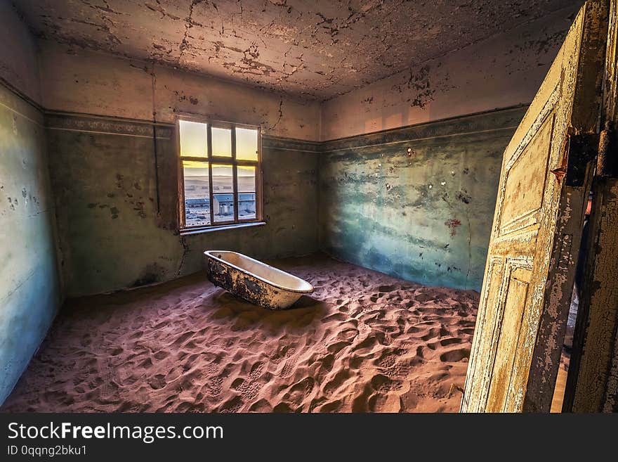 Old bathtube in the ruins of the mining town named Kolmanskop located in the Namib desert near Luderitz in Namibia, Southern Africa. Old bathtube in the ruins of the mining town named Kolmanskop located in the Namib desert near Luderitz in Namibia, Southern Africa