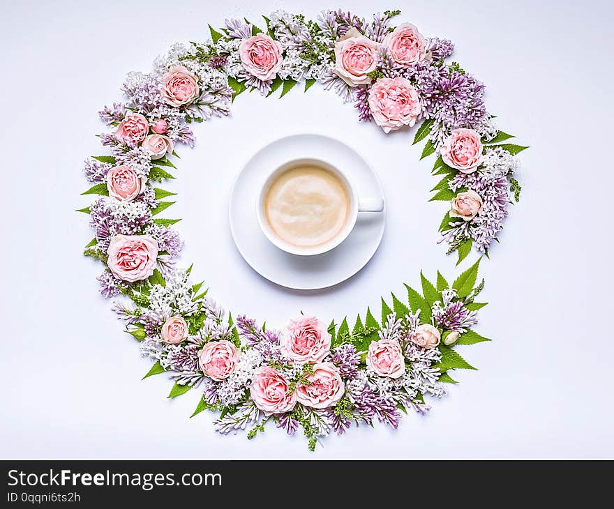 Round frame of flowers: rose, lilac, rowan leaves and cup coffee on a white background. Floral pattern