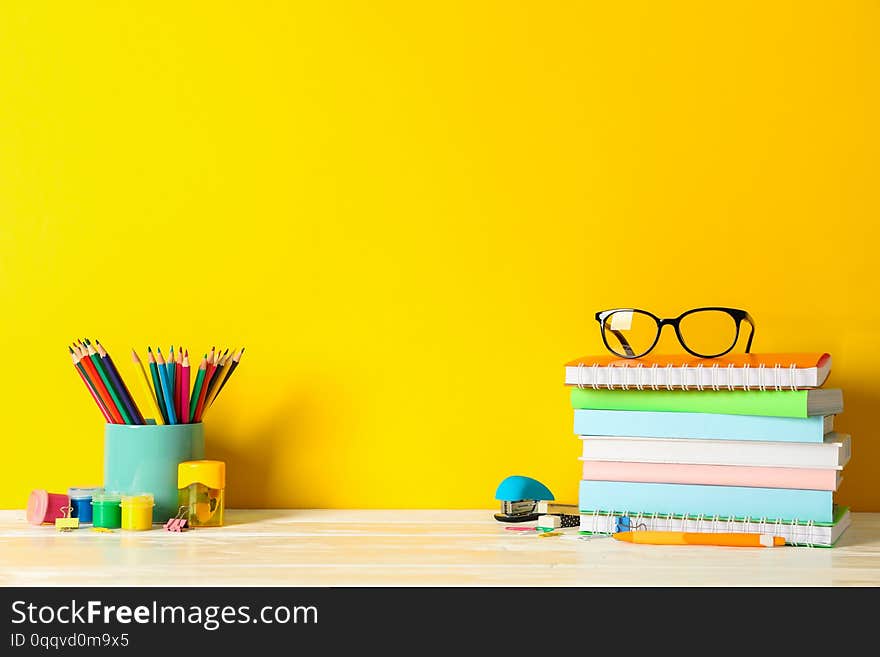 School supplies on wooden table against color background, space for text