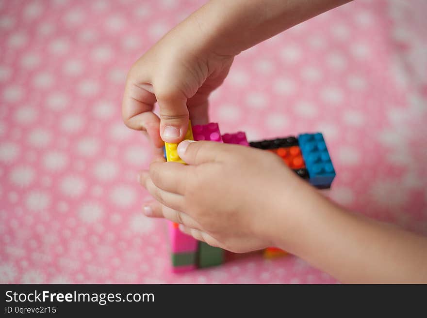 Small hands of the child collects the bright plastic colored Designer. Educational toys and Early learning