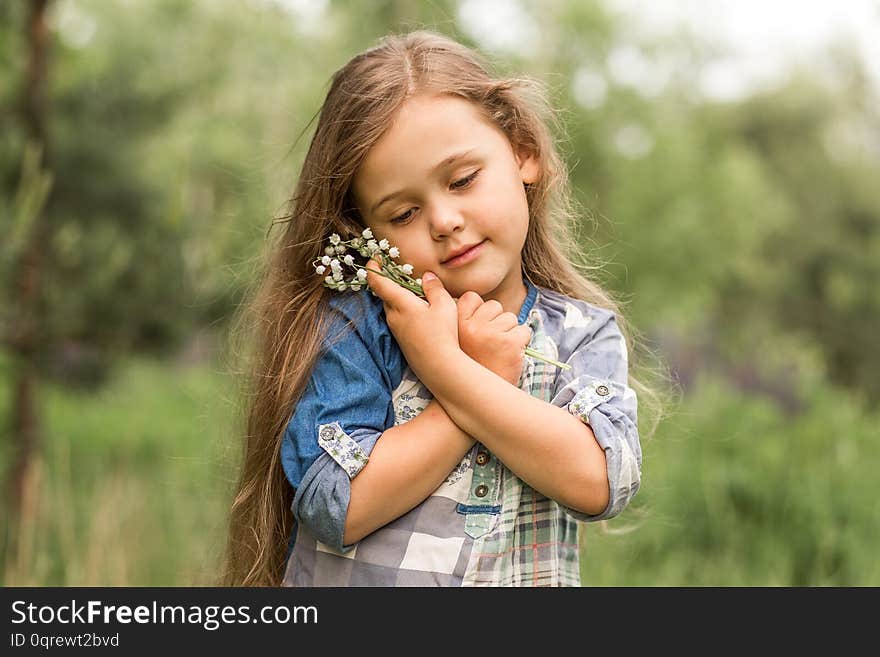 Cute girl with lily of the valley in nature