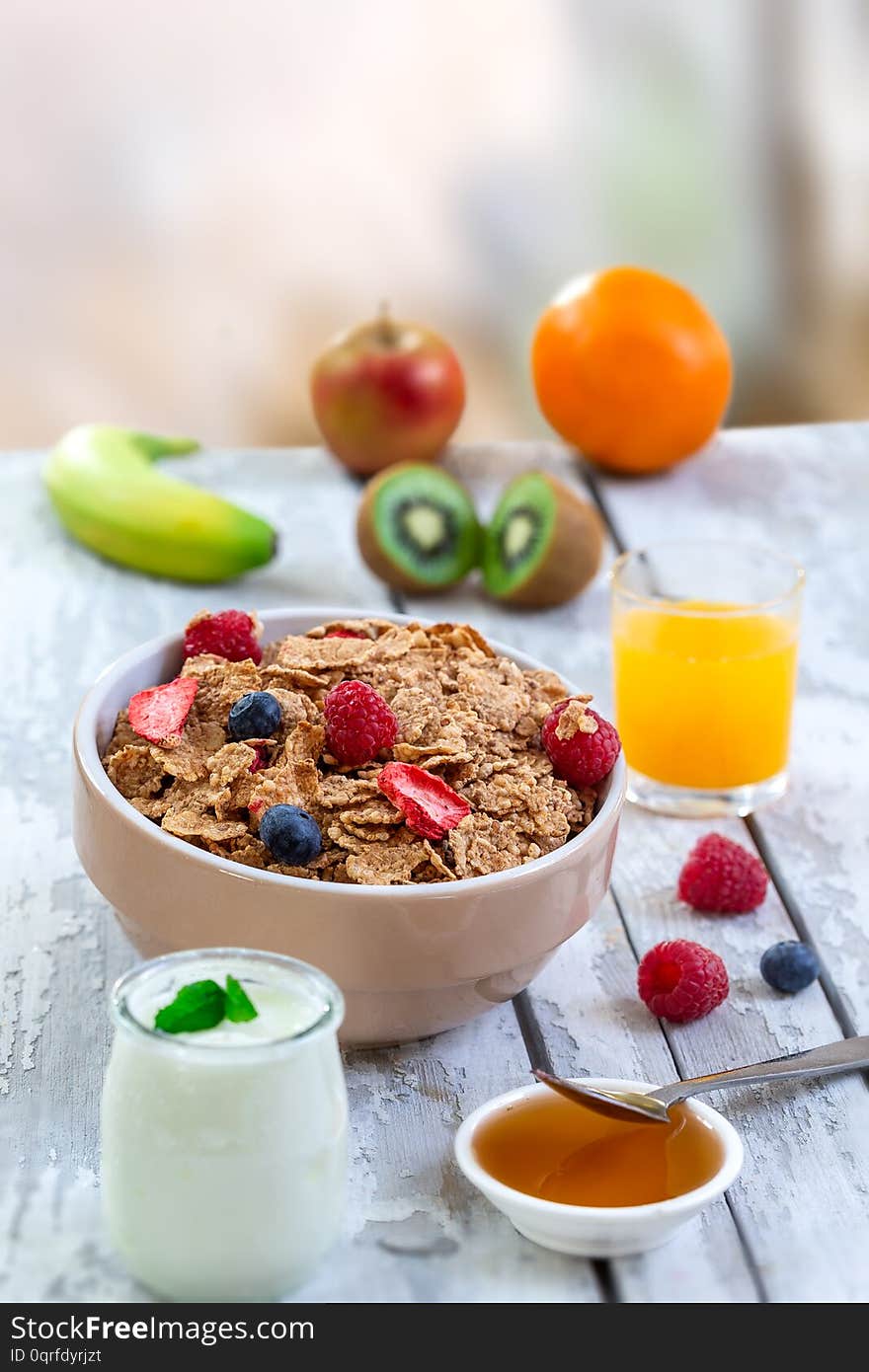 Healthy breakfast with bowl of cereal, orange juice, milk, , and fruits on white background. Balanced diet.