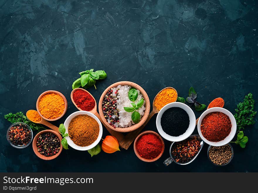 A set of spices and herbs on a stone table. Indian traditional spices. Top view. Free copy space