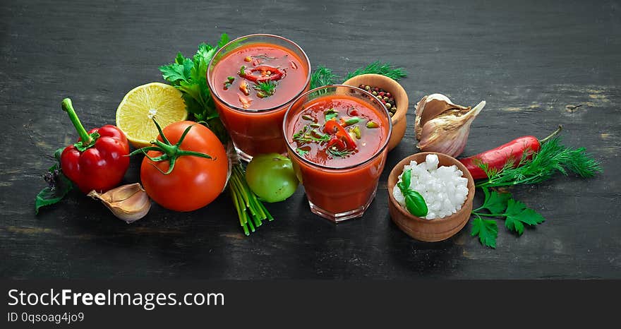 Gazpacho Soup in Glas. Tomato soup with onion, paprika and parsley. Italian cuisine. Top view. On a black background. Free space for text