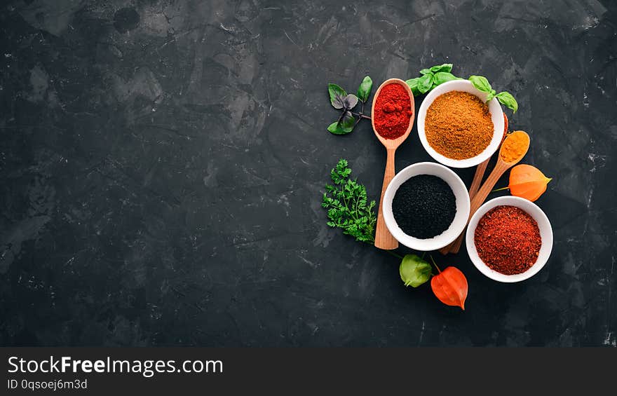 A set of spices and herbs on a stone table. Indian traditional spices. Top view. Free copy space