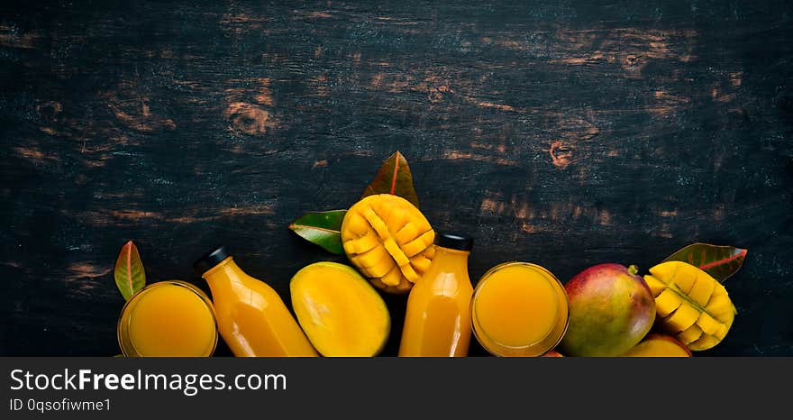 Mango And Fresh Juice On A Black Wooden Background. Tropical Fruits.