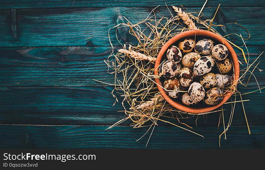 Quail eggs in a wooden bowl.