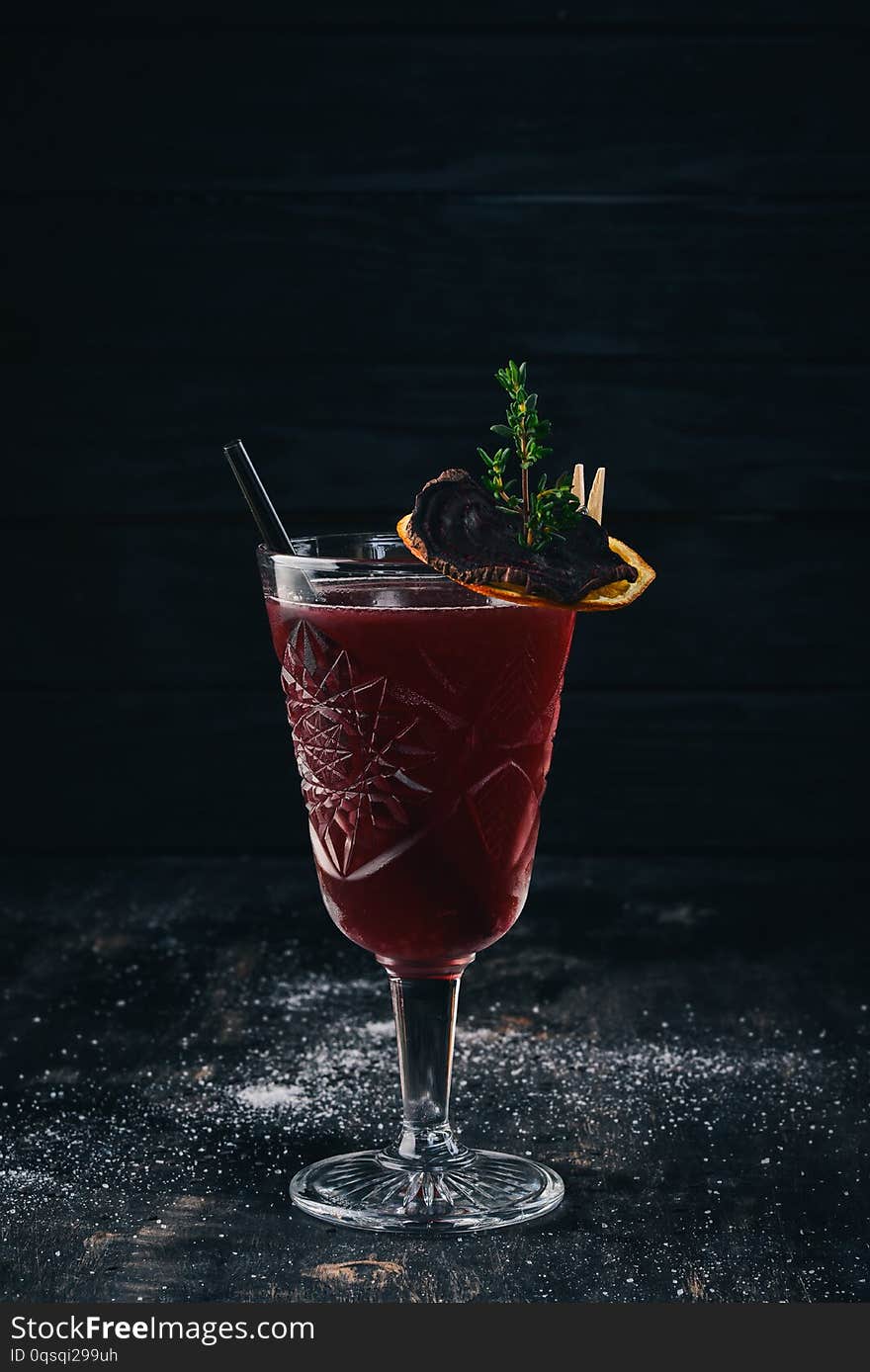 Alcoholic cocktail. Rum, peach liquor, cherry juice. On a black wooden background