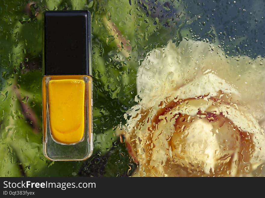 Bottle with yellow nail polish on abstract floral background. Bottle with yellow nail polish on abstract floral background