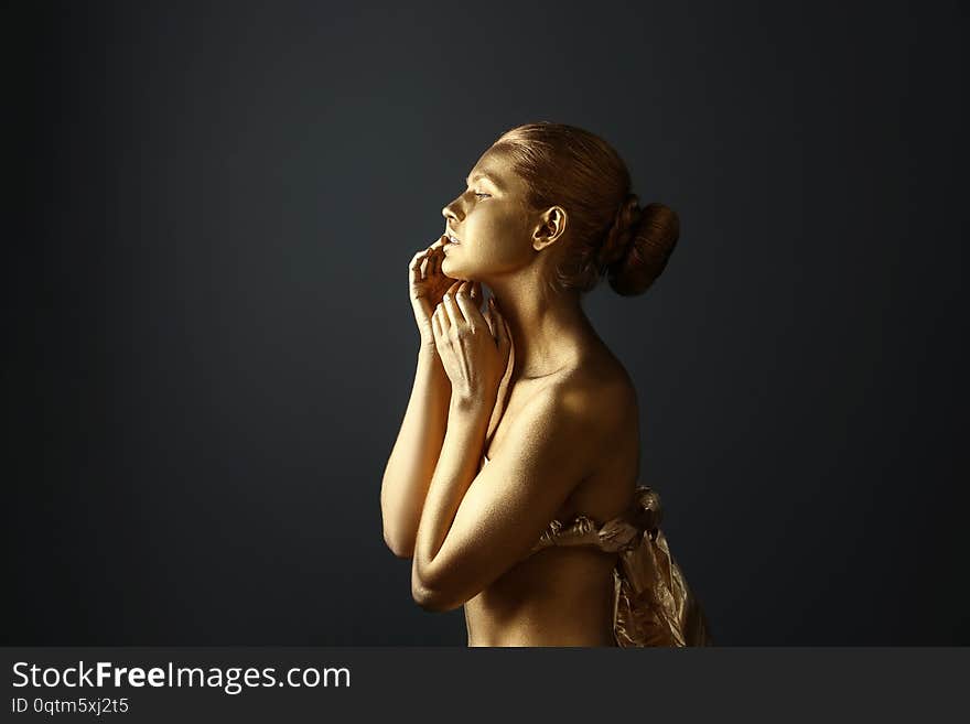 Portrait of beautiful lady with gold paint on skin against grey background